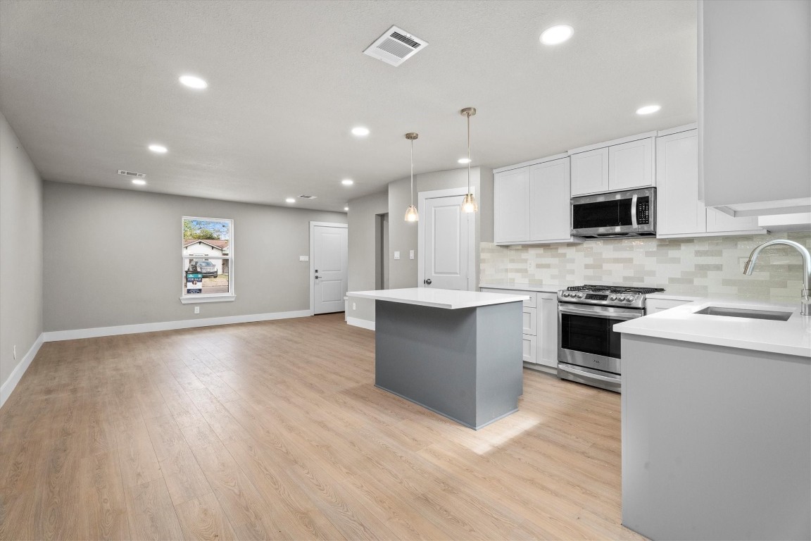 6162 Beldart Street Houston, TX 77033 - Photo 13 of 36 a large kitchen with stainless steel appliances granite countertop a large counter top and a stove top oven