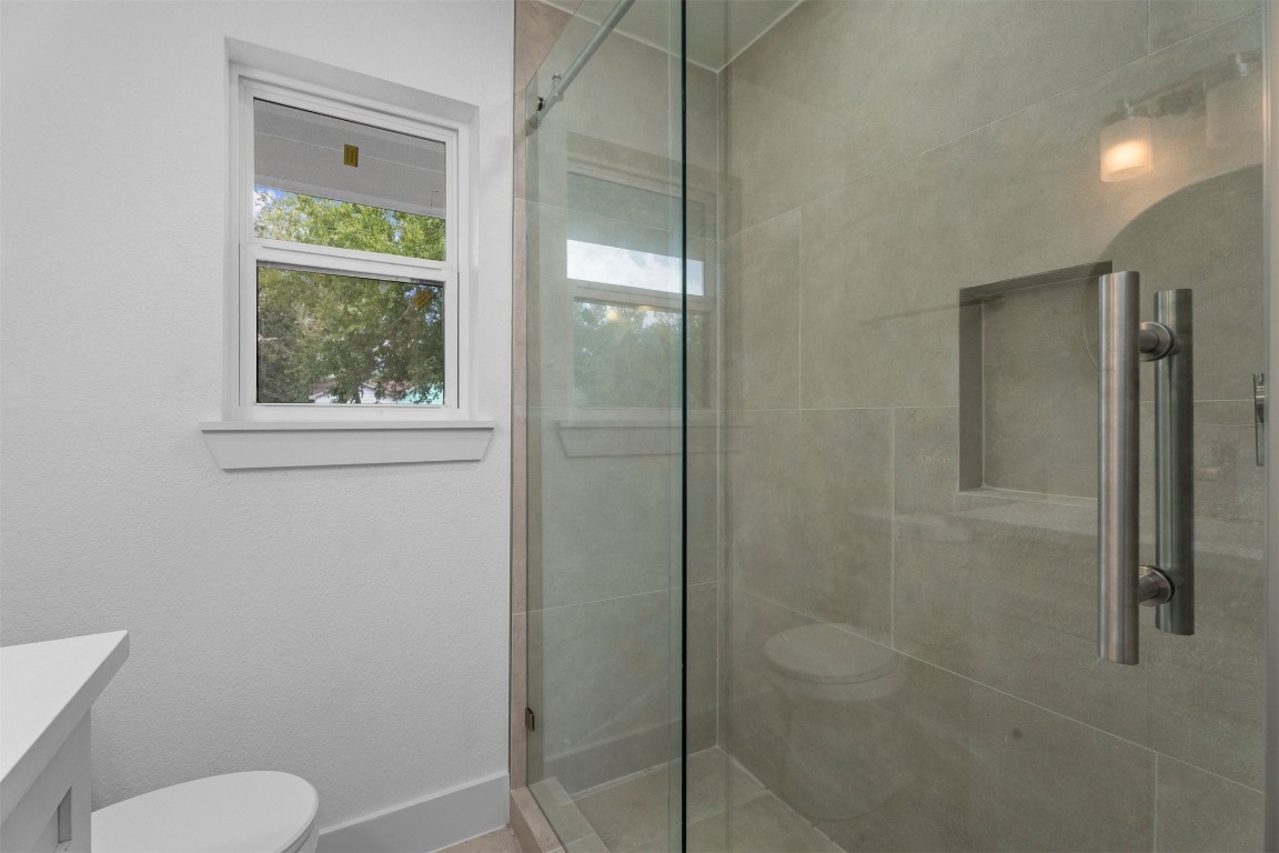 6162 Beldart Street Houston, TX 77033 - Photo 23 of 36 a bathroom with a granite countertop shower a toilet and a sink
