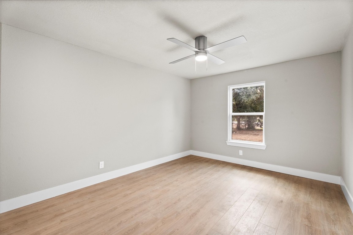 6162 Beldart Street Houston, TX 77033 - Photo 26 of 36 an empty room with wooden floor fan and windows