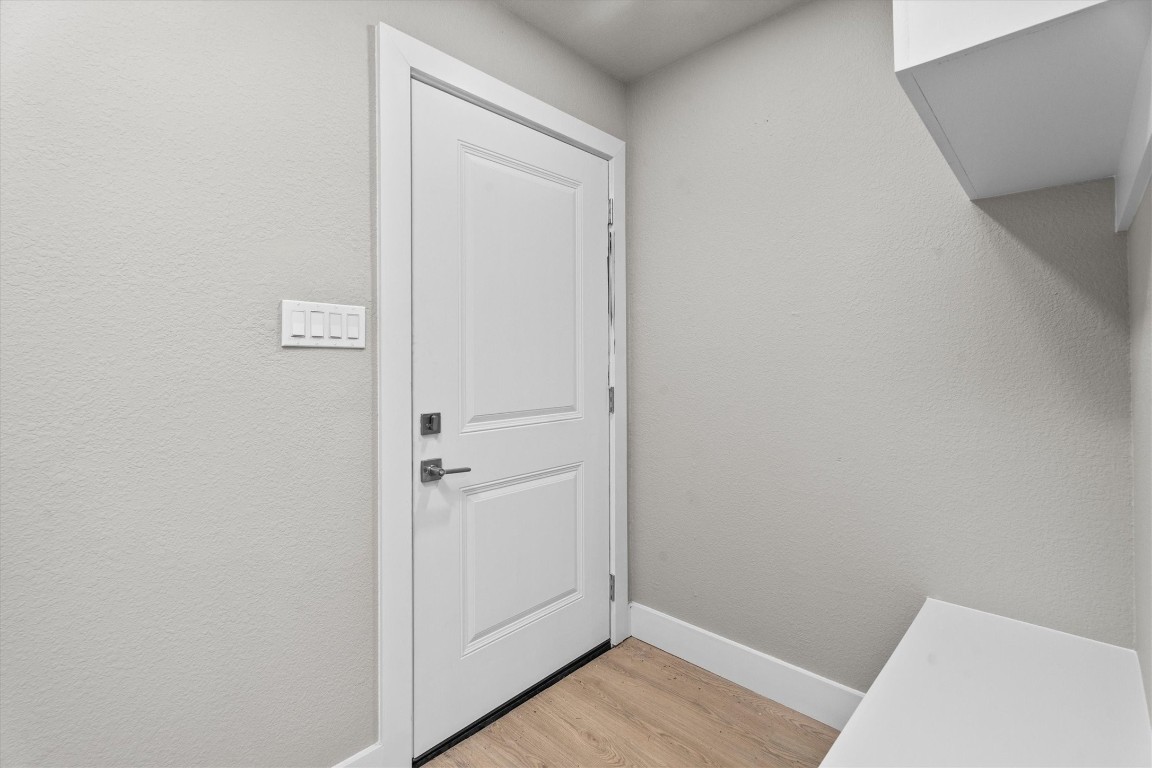 6162 Beldart Street Houston, TX 77033 - Photo 6 of 36 a view of a hallway with wooden floor