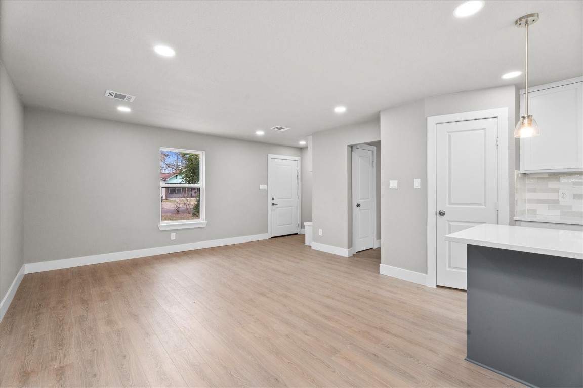 6162 Beldart Street Houston, TX 77033 - Photo 7 of 36 a view of an empty room with a window and wooden floor