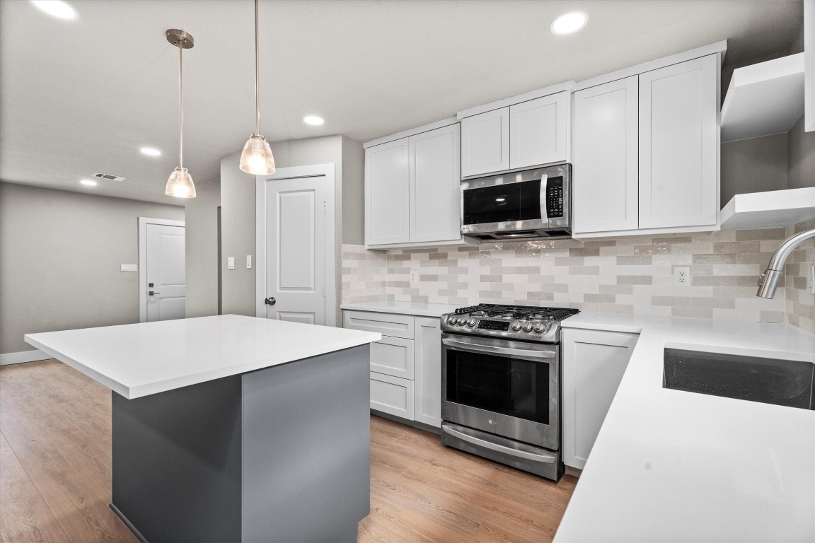 6162 Beldart Street Houston, TX 77033 - Photo 9 of 36 a kitchen with a stove and a microwave