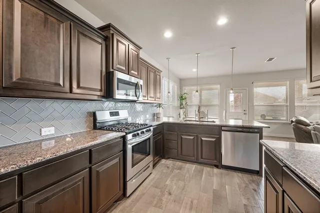 a kitchen with stainless steel appliances granite countertop a stove microwave and cabinets