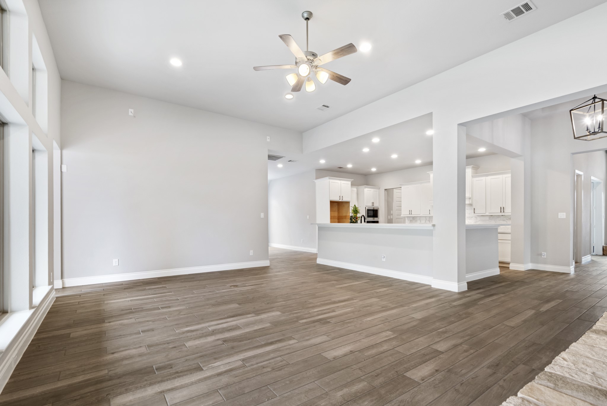 104 Catani Loop Georgetown, TX 78628 - Photo 28 of 34 This spacious living area features wood-look tile flooring, a sloped ceiling with recessed lighting, and a ceiling fan