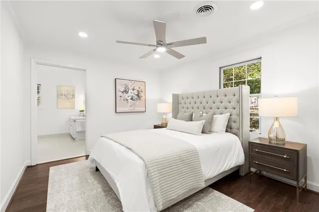 a bedroom with a bed and a lamp on the dresser