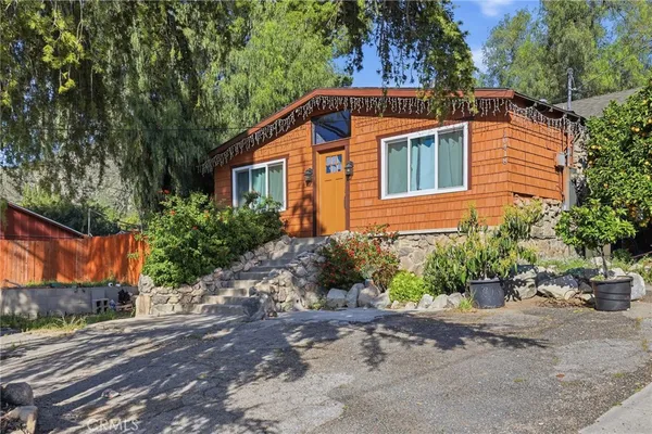 a front view of a house with a yard and potted plants