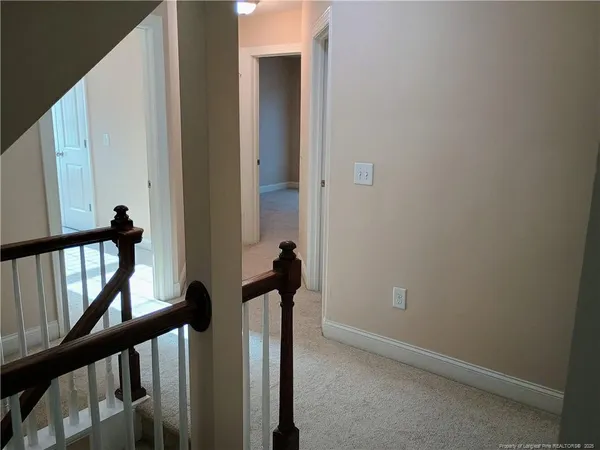 a view of a hallway with wooden floor and stairs
