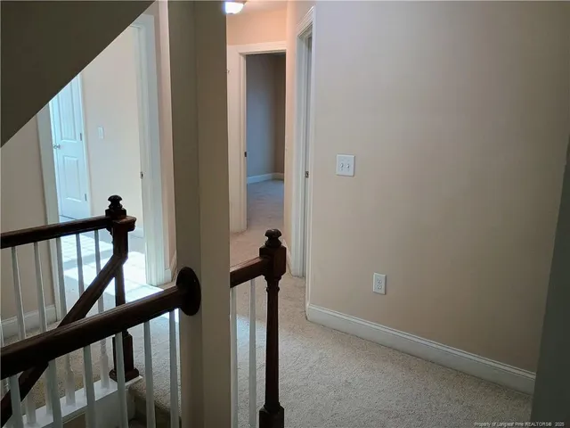 a view of a hallway with wooden floor and stairs