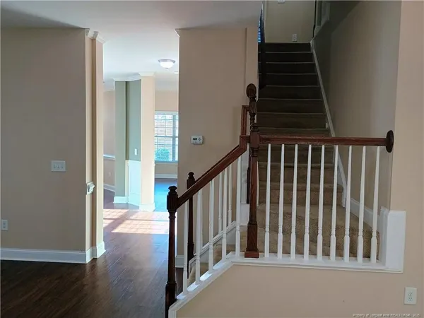 a view of a hallway with wooden floor and stairs