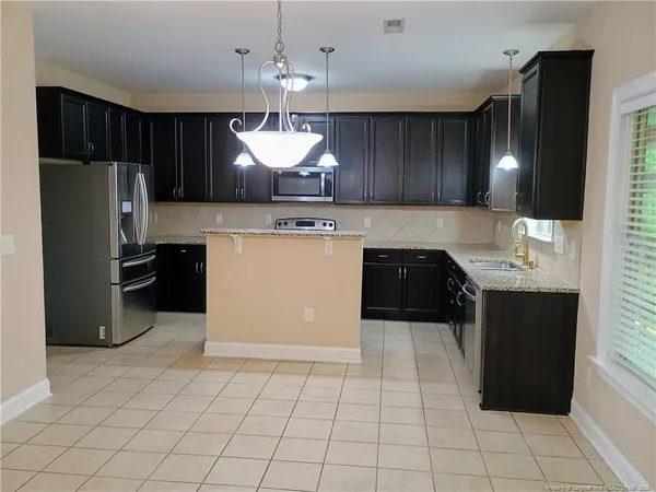 a large kitchen with cabinets and stainless steel appliances