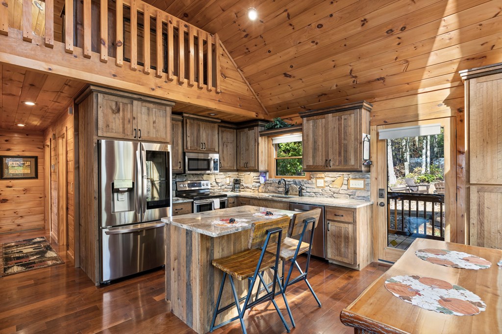 653 The Woods Road Mineral Bluff, GA 30559 - Photo 12 of 56 a kitchen with stainless steel appliances a stove a sink dishwasher a refrigerator and cabinets with wooden floor