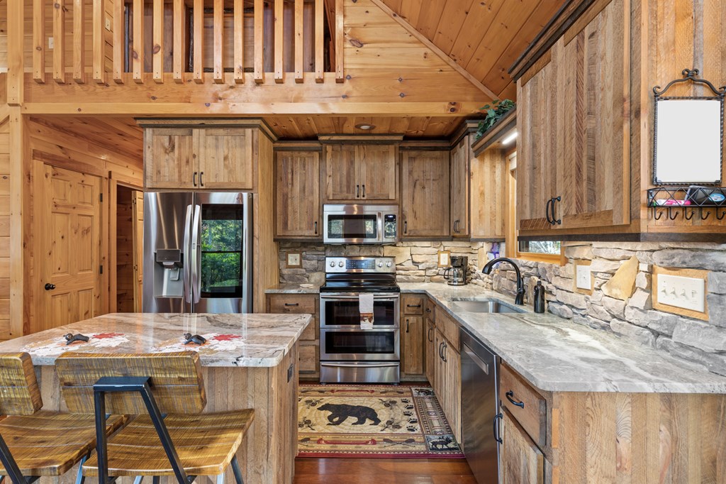 653 The Woods Road Mineral Bluff, GA 30559 - Photo 14 of 56 a kitchen with kitchen island granite countertop a stove and a sink