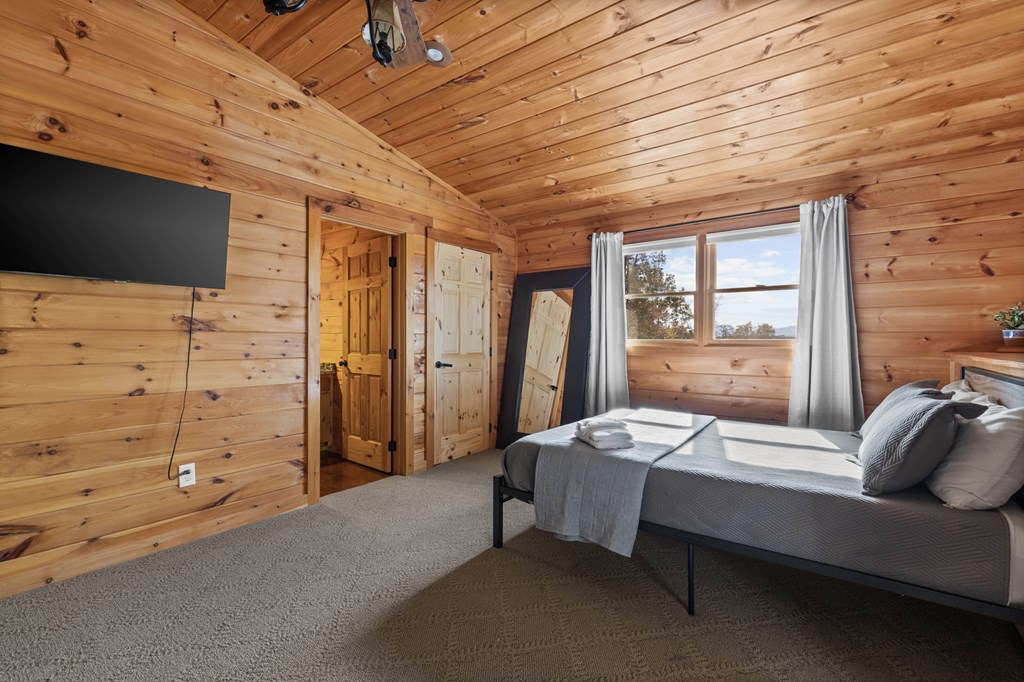 653 The Woods Road Mineral Bluff, GA 30559 - Photo 40 of 56 a bedroom with a bed and a flat tv screen