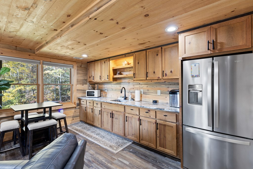 653 The Woods Road Mineral Bluff, GA 30559 - Photo 47 of 56 a kitchen with stainless steel appliances granite countertop a refrigerator a sink dishwasher a stove and white cabinets with wooden floor