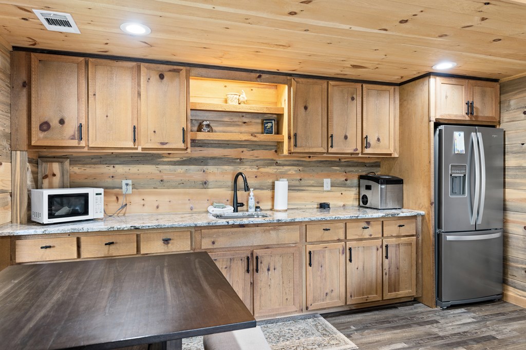 653 The Woods Road Mineral Bluff, GA 30559 - Photo 48 of 56 a kitchen with stainless steel appliances granite countertop a sink refrigerator and cabinets