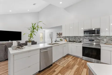 a large white kitchen with cabinets and stainless steel appliances