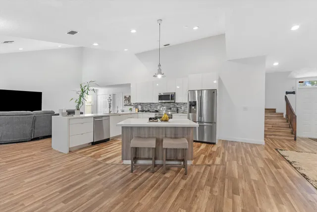 an empty room with windows and ceiling fan