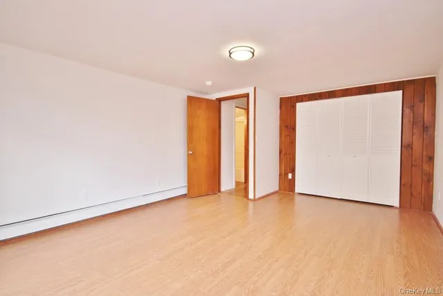an empty room with closet and wooden floor