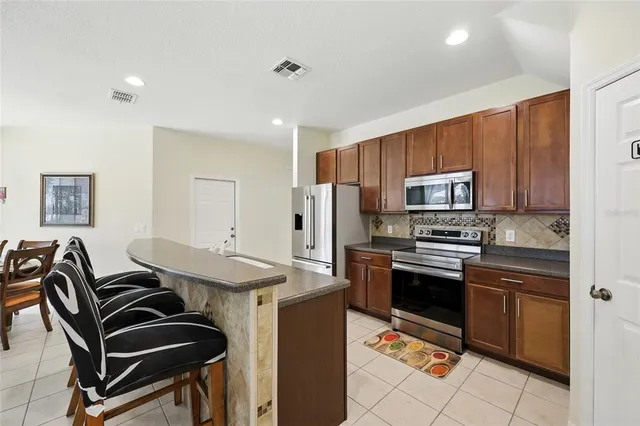 a kitchen with a sink a refrigerator and a stove top oven
