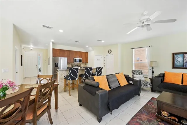 a kitchen with stainless steel appliances granite countertop a table chairs in it and wooden floors