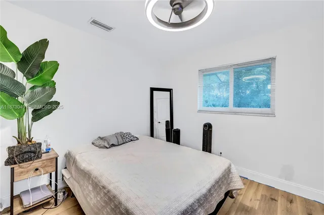 a bedroom with a bed and a potted plant