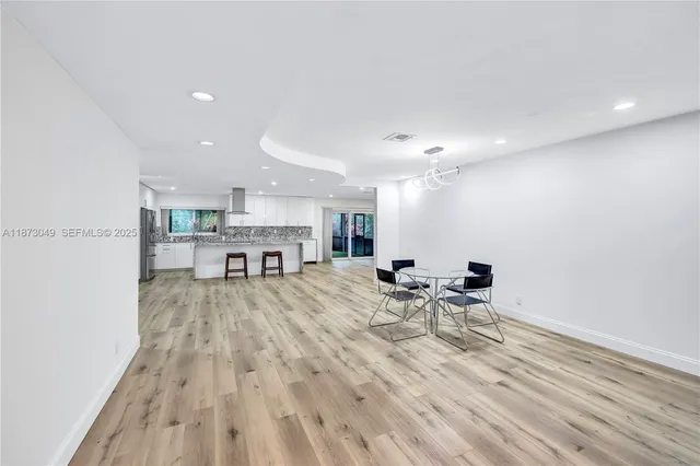 a view of a kitchen with a dining table chairs and wooden floor
