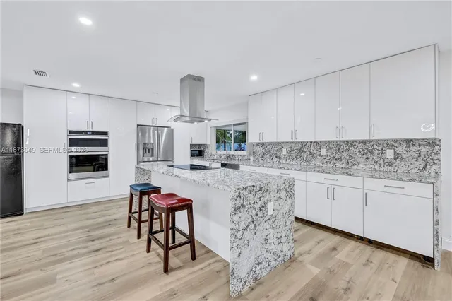 a kitchen with stainless steel appliances granite countertop a sink and cabinets