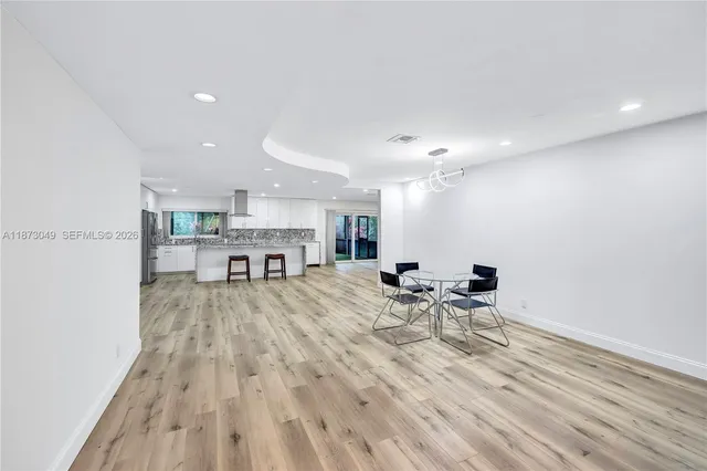 a view of a kitchen with a dining table chairs and wooden floor