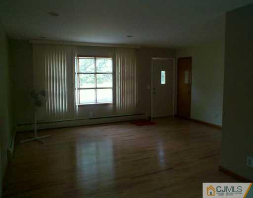 833 Inman Avenue Edison, NJ 08820 - Photo 6 of 8 a view of an empty room with wooden floor and a window