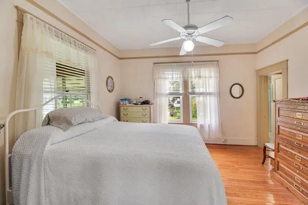 a bedroom with a large bed chandelier and a window