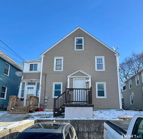 a front view of a house with cars parked