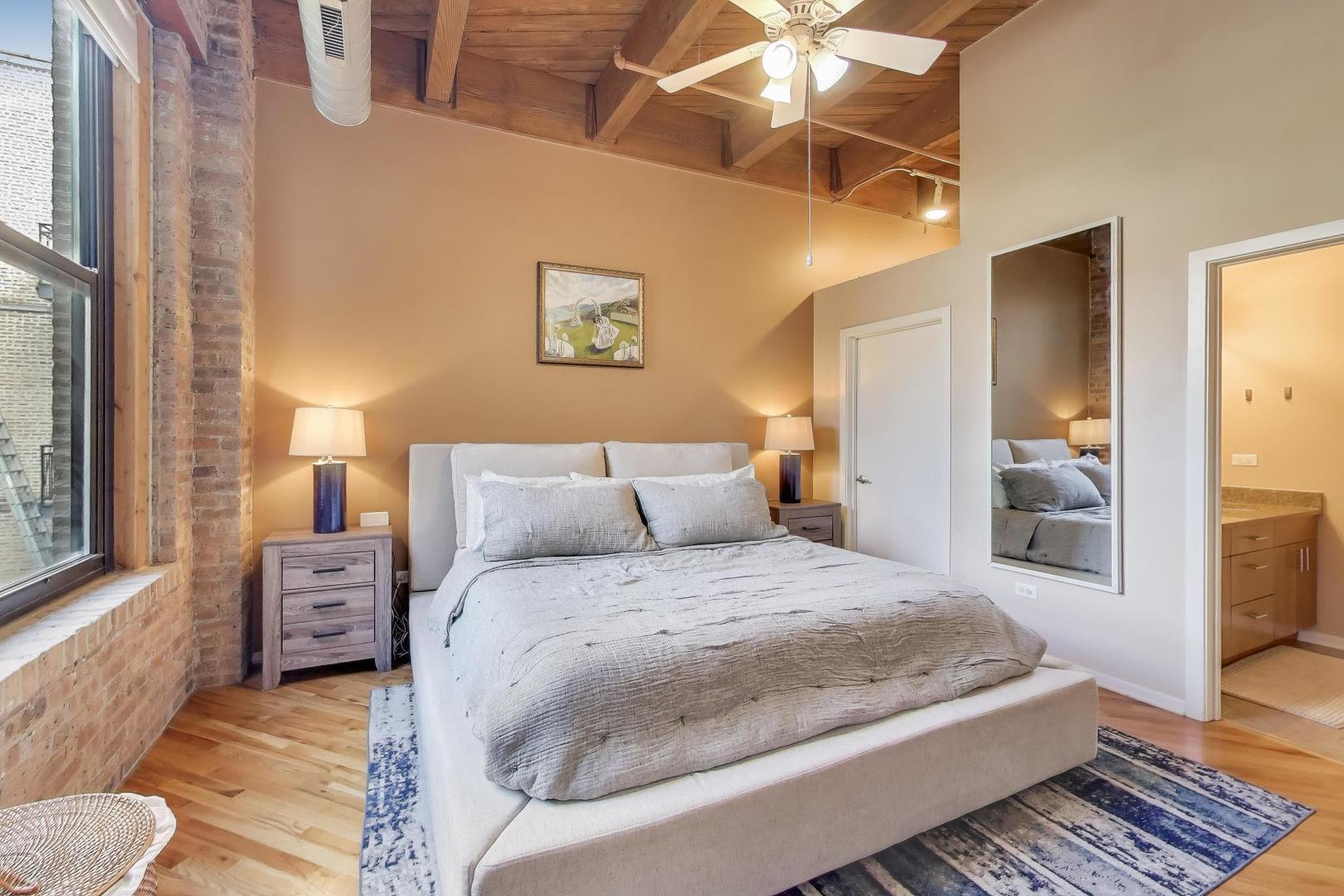 1040 West Adams Street, Unit 370 Chicago, IL 60607 - Photo 8 of 27 a bedroom with a large bed and a chandelier