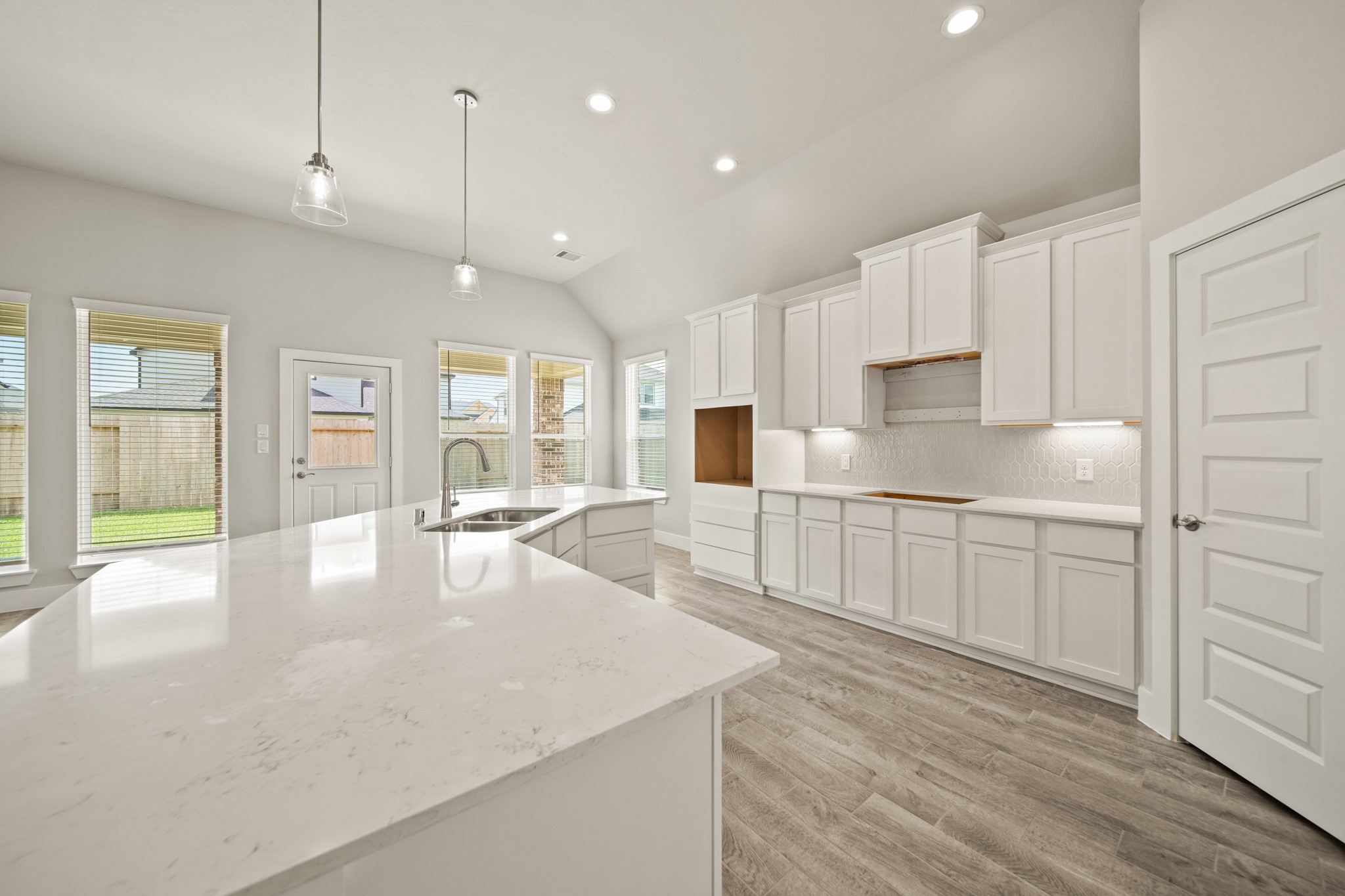 408 Inner Cove Lane Waller, TX 77484 - Photo 8 of 48 a kitchen with stainless steel appliances granite countertop a refrigerator a sink dishwasher and white cabinets with wooden floor