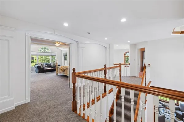 a view of a hallway with wooden floor and windows