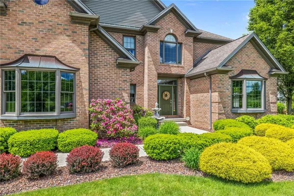 a front view of a house with a garden and plants