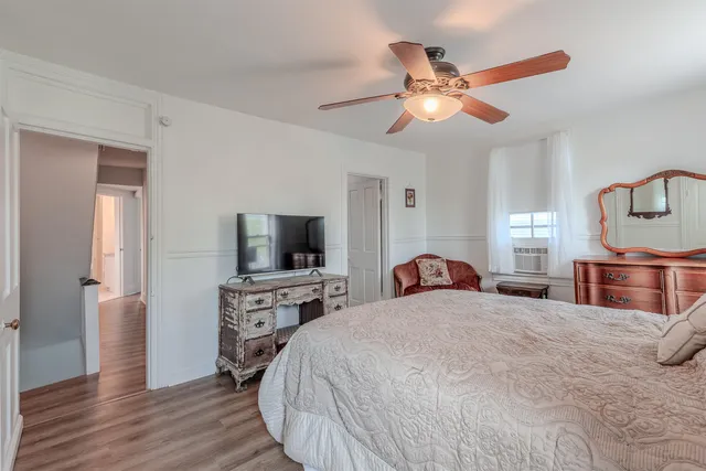 a bedroom with a bed and a flat tv screen on dresser