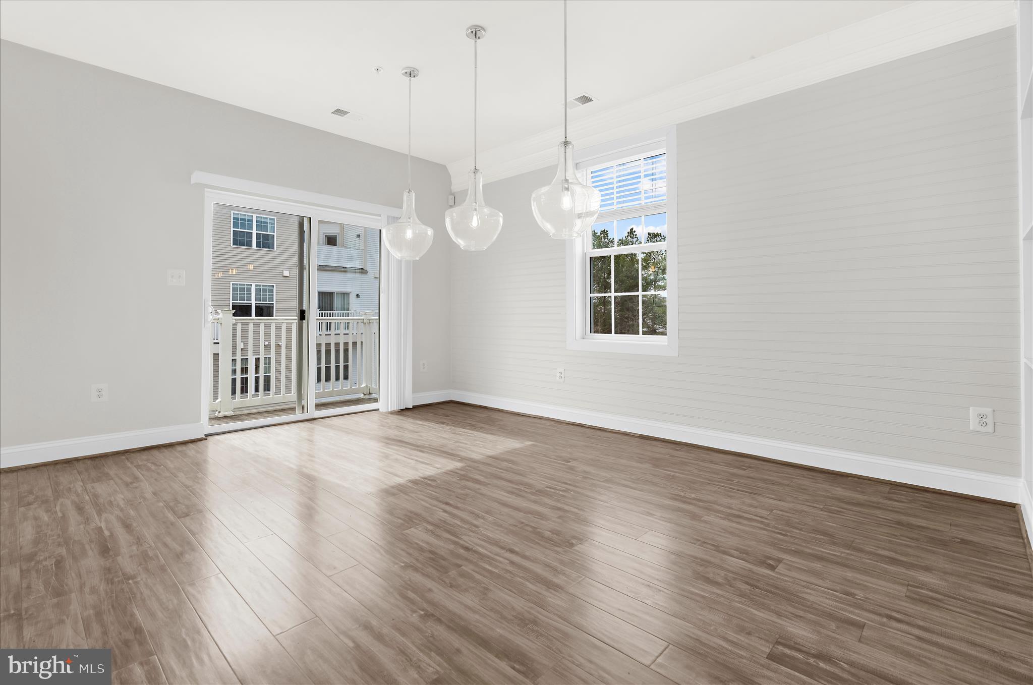 1704 Fieldstone Court Hanover, MD 21076 - Photo 14 of 47 an empty room with wooden floor and windows