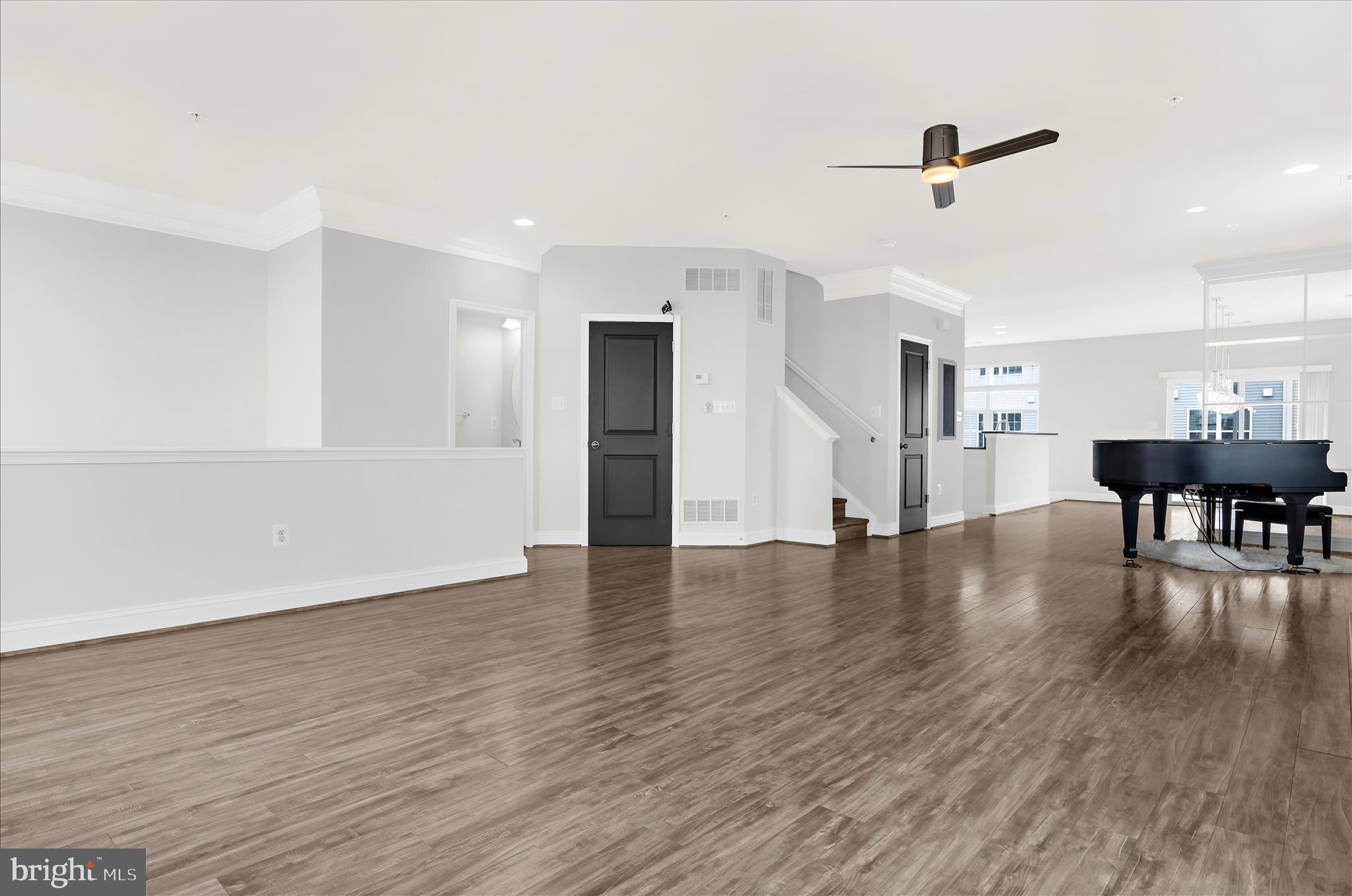 1704 Fieldstone Court Hanover, MD 21076 - Photo 10 of 47 a view of a livingroom with furniture wooden floor a ceiling fan and windows