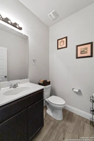 a bathroom with a granite countertop toilet a sink and a mirror