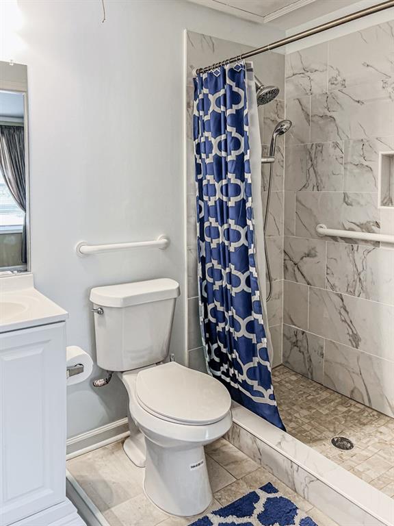 3605 Shallowford Road Marietta, GA 30062 - Photo 27 of 42 a white toilet sitting next to a shower curtain