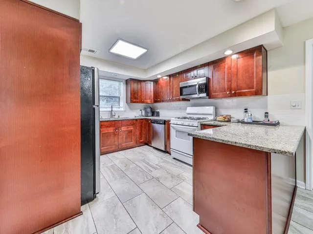 a kitchen with stainless steel appliances granite countertop a stove sink and cabinets