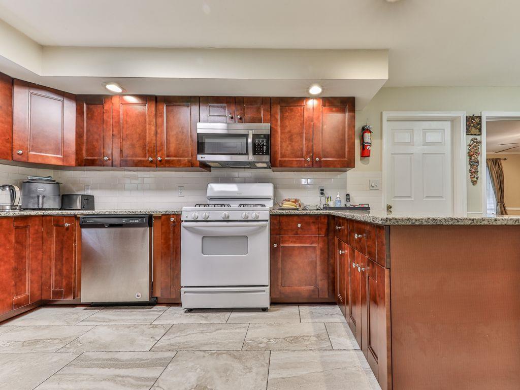 3605 Shallowford Road Marietta, GA 30062 - Photo 9 of 42 a kitchen with granite countertop a stove top oven sink and cabinets