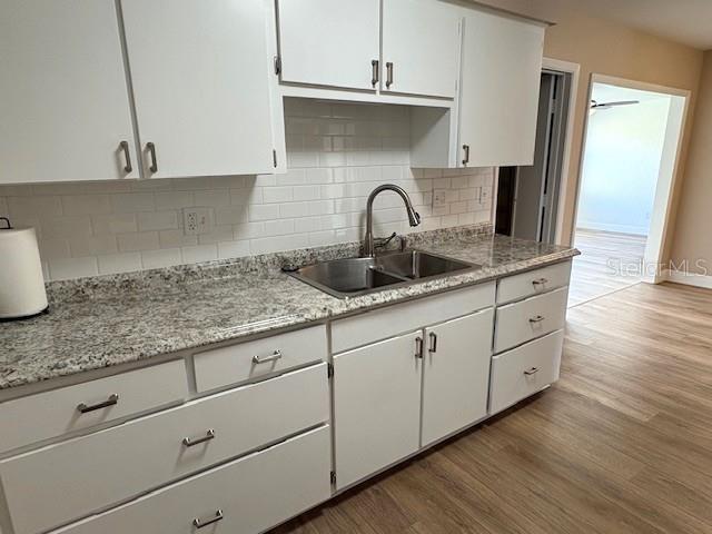 1005 Rickenbacker Drive Sun City Center, FL 33573 - Photo 11 of 57 a kitchen with granite countertop white cabinets and sink