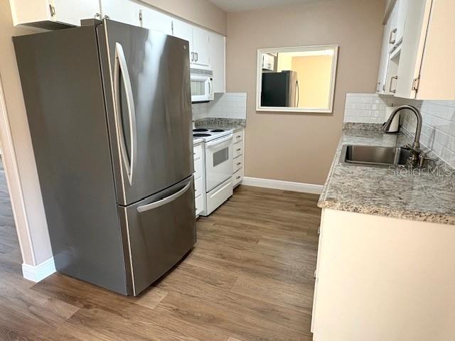 1005 Rickenbacker Drive Sun City Center, FL 33573 - Photo 9 of 57 a kitchen with granite countertop a refrigerator and a sink