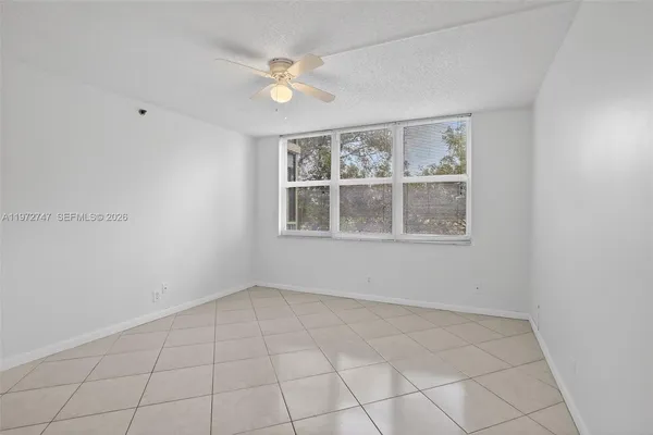 an empty room with windows and fan