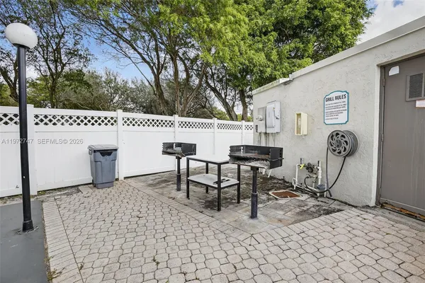 a roof deck with table and chairs and potted plants