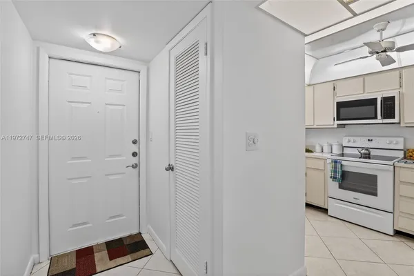 a view of a kitchen with white cabinets and stainless steel appliances