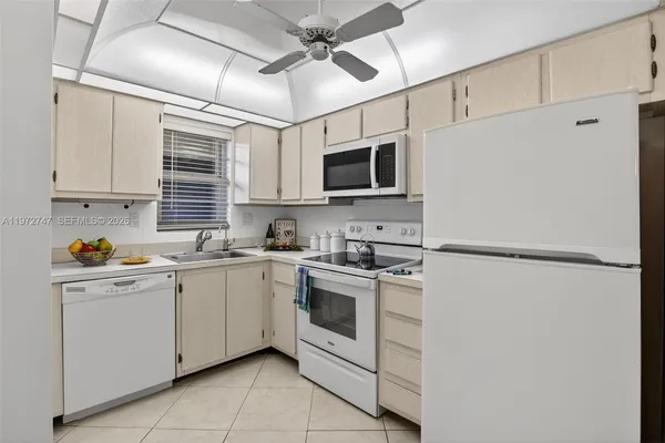 a kitchen with stainless steel appliances white cabinets and white appliances