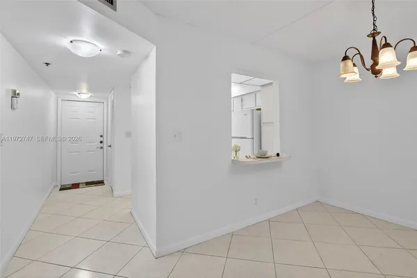 a view of a hallway with wooden floor and cabinet