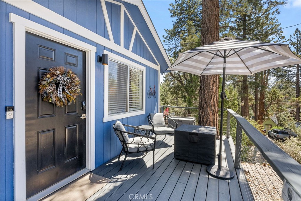 a patio with wooden floor table and chairs